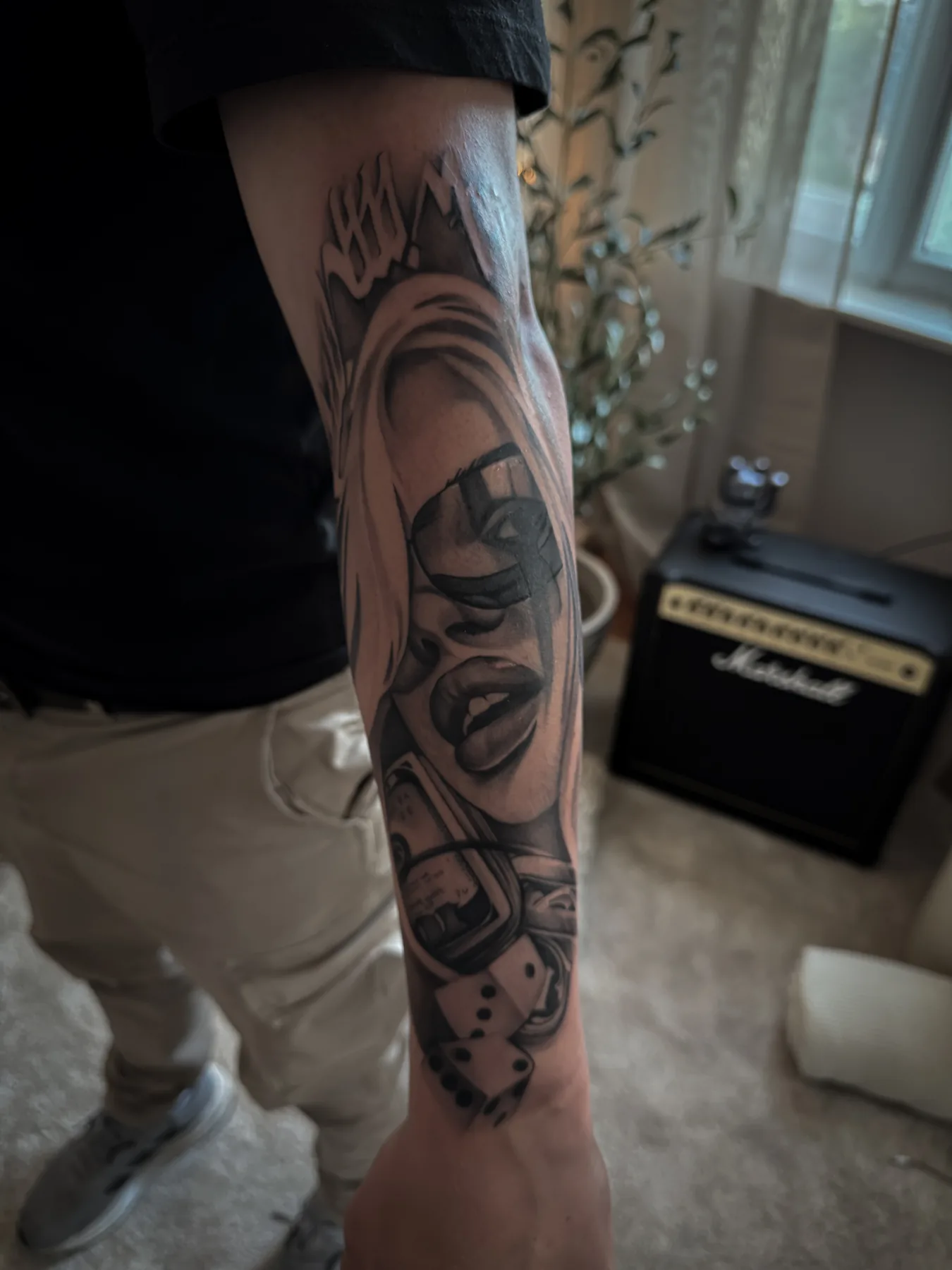 Black-and-Grey Unterarmtattoo von Elena mit Gesichtsmotiv